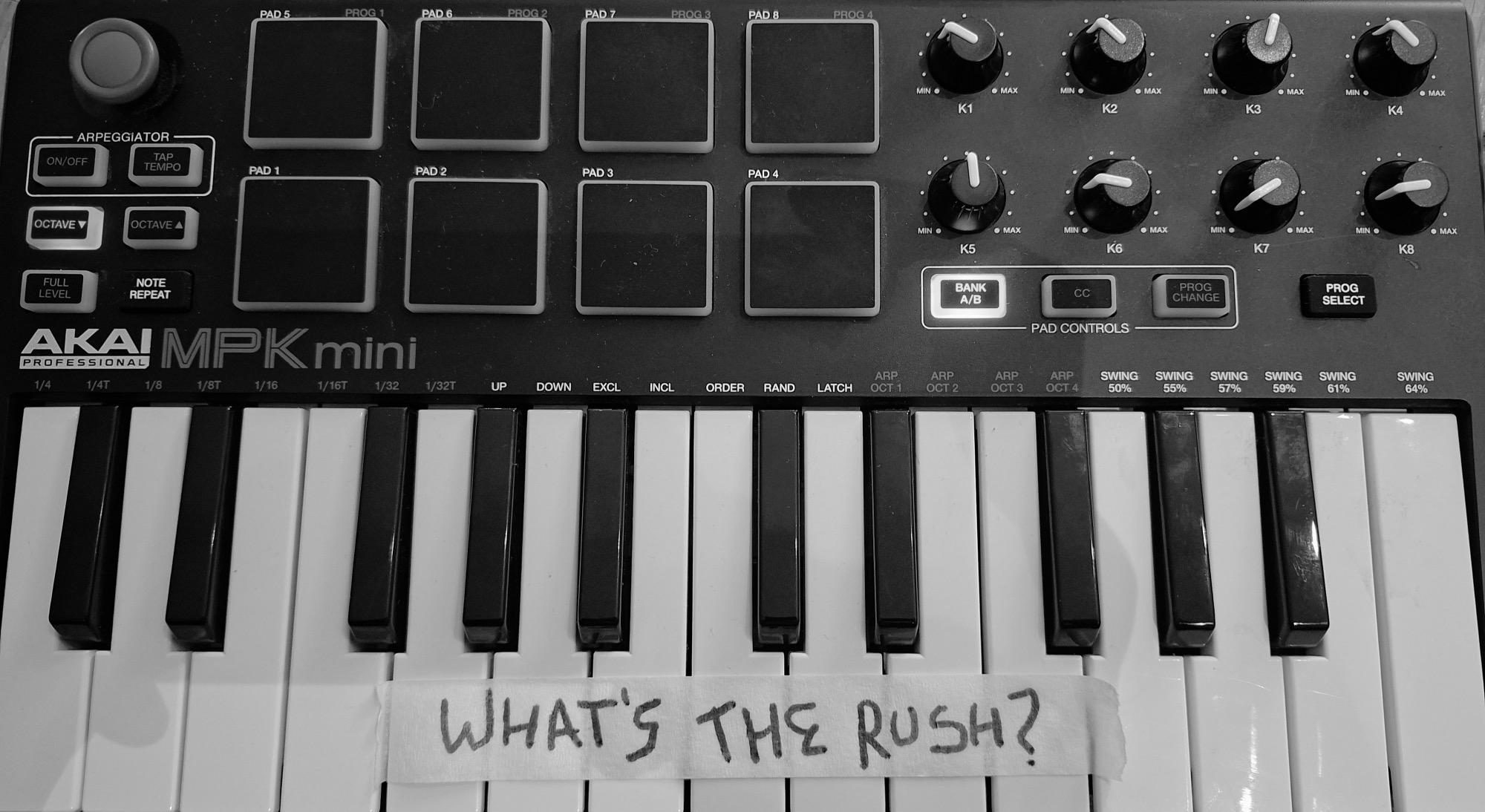 Akai MPK Mini with a 'WHAT'S THE RUSH?' tape strip across the keys